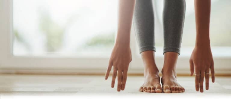 hands reaching to touch toes, implying the person is stretching